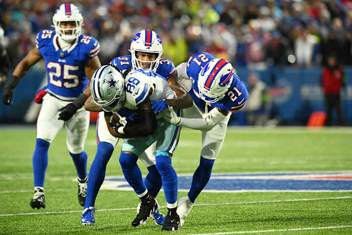 Buffalo Bills cornerback Rasul Douglas (31) and safety Jordan Poyer (21) tackle Dallas Cowboys wide receiver CeeDee Lamb (88) in the first half at Highmark Stadium.